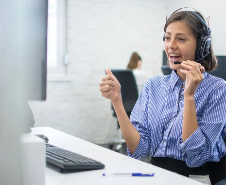 Una persona conversando por audifonos, brindando orientacion y soporte a una persona